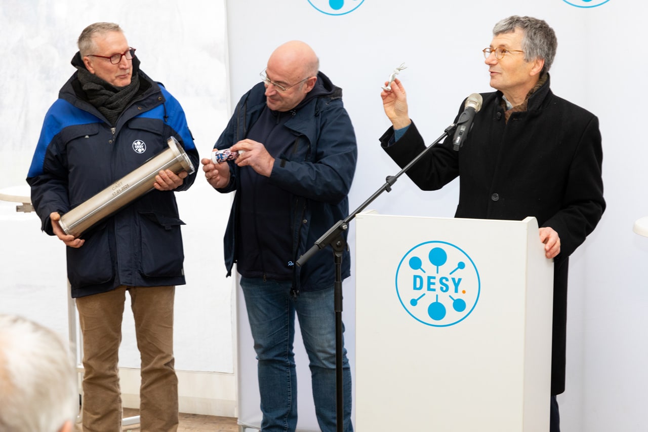 Foto von der Befüllung eines Rohrs, das später verschlossen und im Fundament des Neubaus einbetoniert wird.