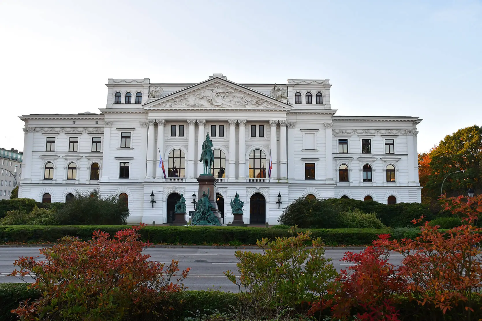 Das Altonaer Rathaus ist ein weißer Prachtbau in neo-klassiszistischem Stil. Der Vorplatz ist mit Büschen und Blumenbeeten begrünt. Vor dem Eingang ist ein Reiterstandbild von Kaiser Wilhelm dem 1. platziert.