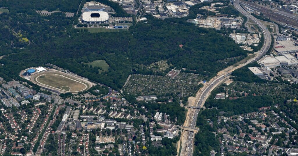 Luftaufnahme des künftigen Gebiets Quartiere am Volkspark und einer Autobahn, die die urbanen Strukturen und Verkehrswege zeigt.