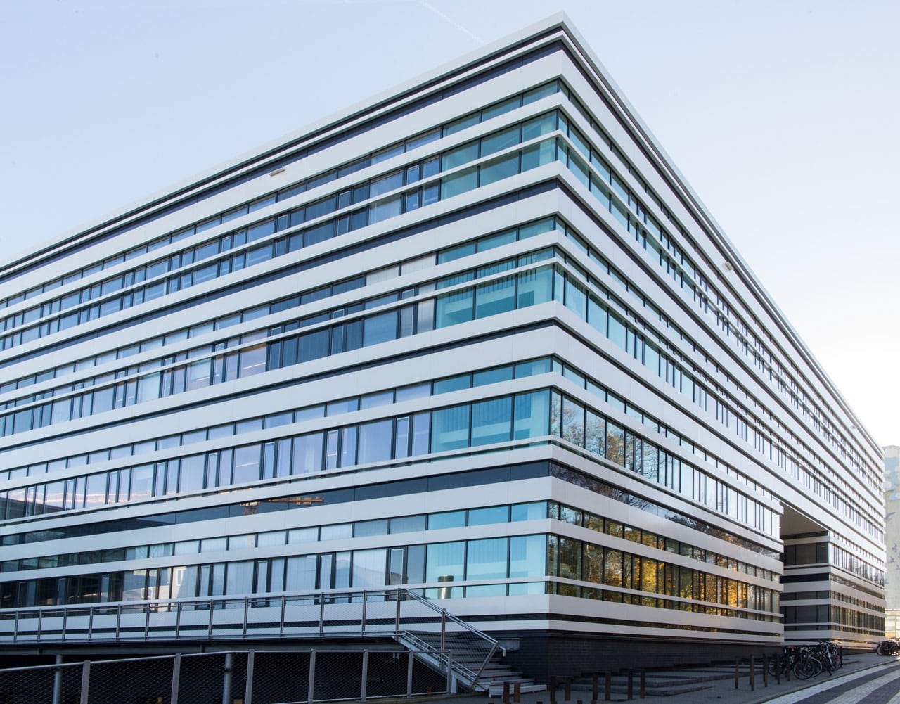 Foto vom CSSB-Gebäude im morgendlichen Sonnenlicht. Das Gebäude ist vier Stockwerke hoch und hat viele Fenster.