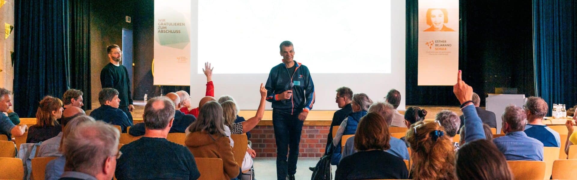 Ein Mann hält eine Präsentation vor einer Gruppe von Zuhörern in einem Konferenzraum.