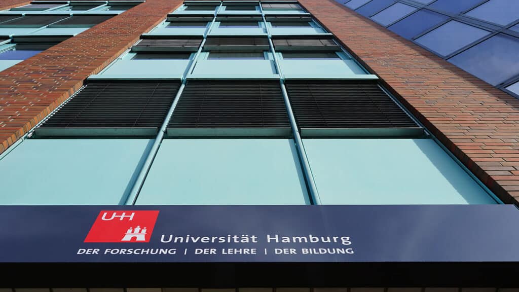 Foto vom Eingang eines Bürogebäudes mit dem Logo der Universität Hamburg darauf.